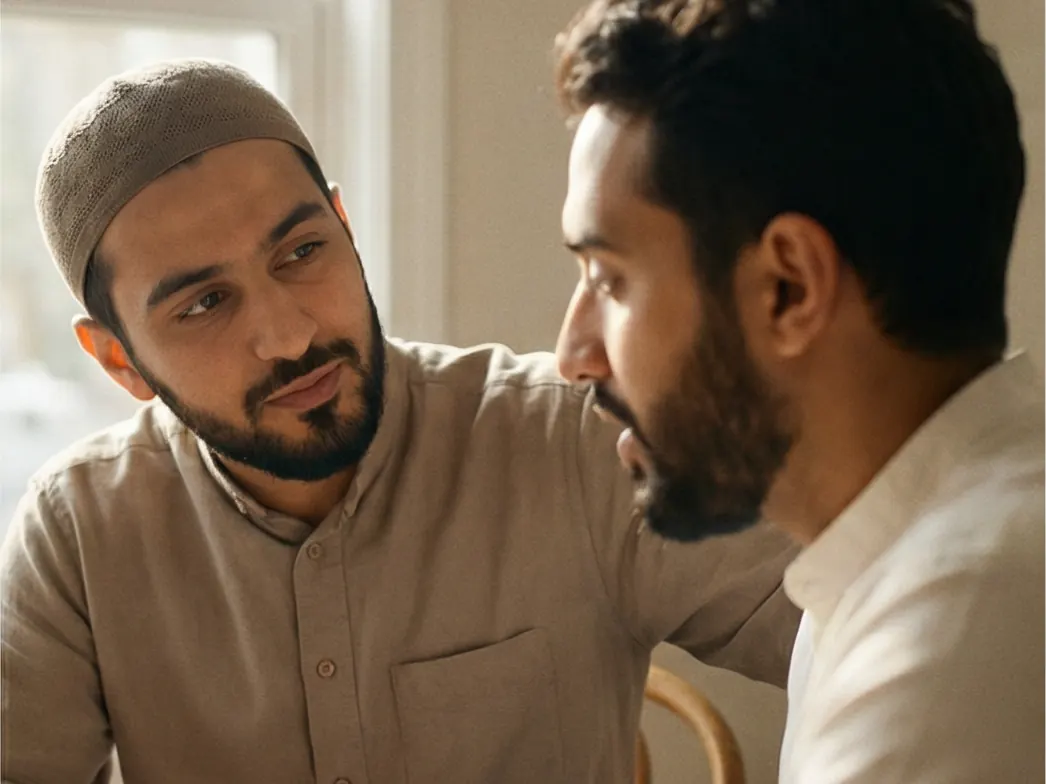 Two men in conversation, one with a hand on the other's shoulder